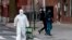 A woman wearing a hazmat suit and googles pulls her grocery cart in the streets in Queens, a borough of New York City, amid the coronavirus pandemic on April 20, 2020.