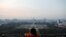 A girl looks on National Monument (Monas) as smog covers the capital city of Jakarta, Indonesia, July 4, 2019. 