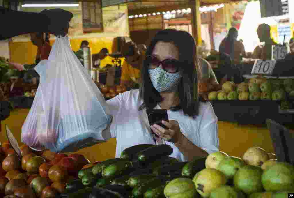 Una mujer con máscara protectora compra verduras en un mercado en La Habana, Cuba.