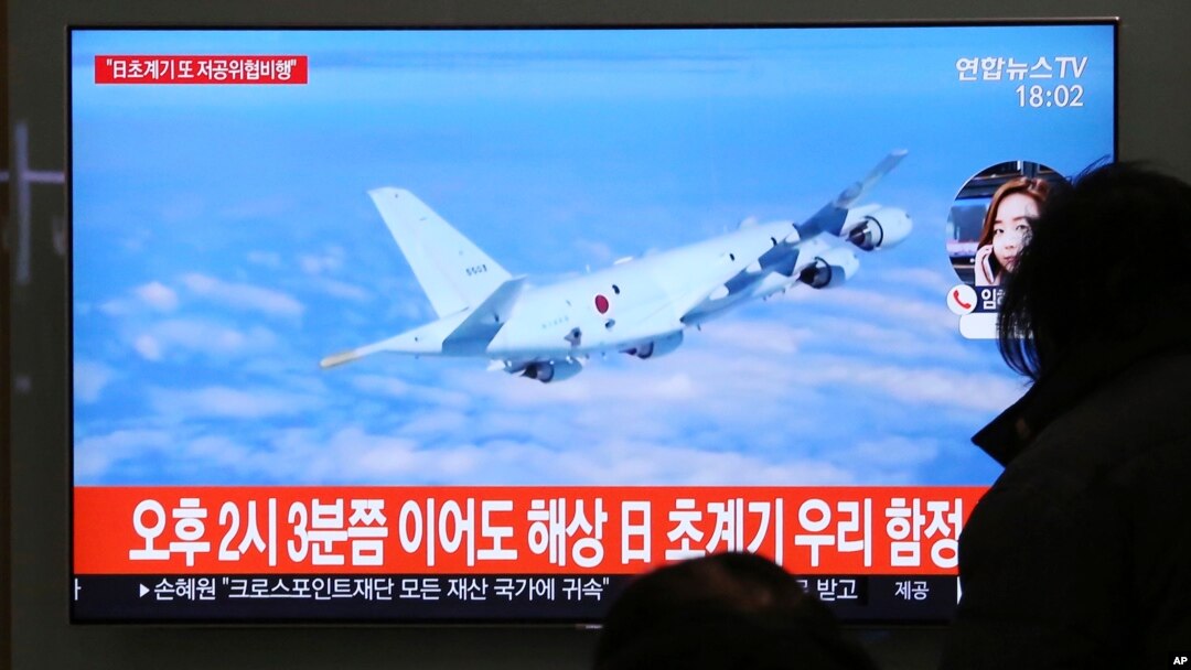 People watch a TV screen showing file footage of a Japanese patrol plane during a news program at the Seoul Railway Station in Seoul, South Korea, Jan. 23, 2019. 