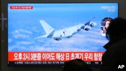 People watch a TV screen showing file footage of a Japanese patrol plane during a news program at the Seoul Railway Station in Seoul, South Korea, Jan. 23, 2019. 