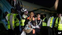 FILE - Nigerian returnees from Libya disembark from a plane upon arrival at the Murtala Muhammed International Airport in Lagos, Nigeria, Dec. 5, 2017. 