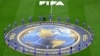 2026 월드컵 경기가 열리는 구장에서 FIFA 자원봉사자들이 공식 메달 배너 주변에 모여있다.