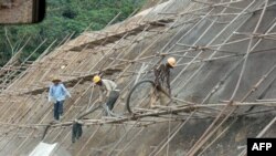 Des ouvriers chinois et congolais sur un chantier près du village de Saharas, en train de construire une section de la nouvelle route entre Brazzaville, Dolisie et Pointe Noire, le 26 mars 2011. (Photo: Laudes Martial Mbon / AFP)