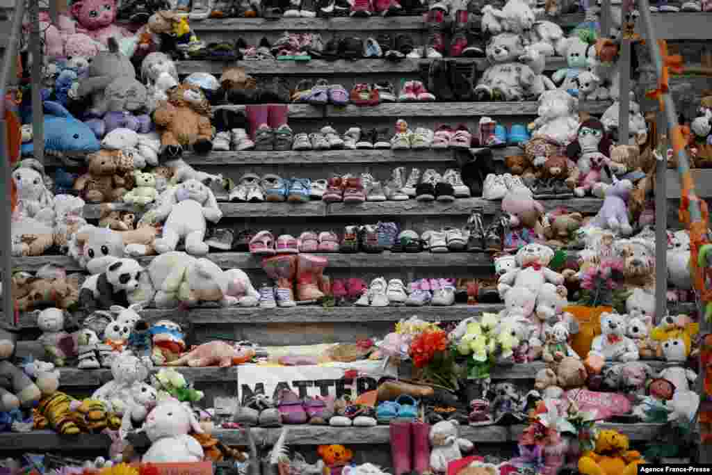 Children shoes and stuffed animals sit on the steps as a tribute to the missing children of the former Mohawk Institute Residential School, in Brantford, Canada, Nov. 9, 2021.