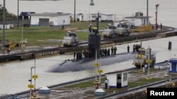 美国海军快速攻击核潜艇哥伦布号(SSN-762) 2015年7月10日航行通过巴拿马运河的米拉弗洛雷斯船闸(Miraflores Locks)，潜艇人员站在哥伦布号的顶端。 （路透社档案照片）