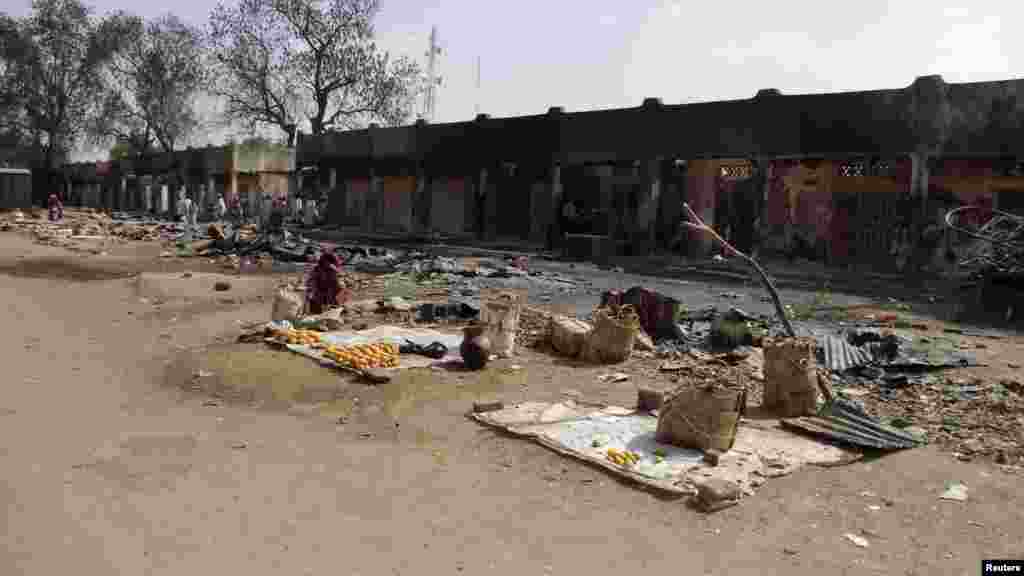 A woman sits amongst the burnt ruins of the Bama Market, which was destroyed by gunmen in last Thursday's attack, in Maiduguri, northeast Nigeria April 29, 2013.