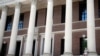 FILE - A man wearing a face mask in concern for the coronavirus, talks on his phone, June 26, 2020, on the steps of Harvard University's Widener Library in Cambridge, Mass.