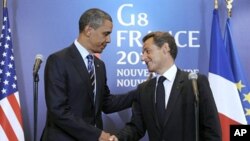 ປະທານາທິບໍດີຝຣັ່ງທ່ານ Nicolas Sarkozy (ຂວາ) ຈັບມືກັບປະທານາທິບໍດີສະຫະລັດທ່ານບາຣັກໂອບາມາ ລຸນຫຼັງການຖະແຫຼງຂ່າວຮ່ວມກັນຫຼັງຈາກການພົບປະ ຢູ່ຂ້າງນອກກອງປະຊຸມສຸດຍອດກຸ່ມຈີ 8 ທີ່ເມືອງ Deauville (27 ພຶດສະພາ 2011)