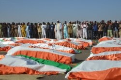 The Imam of the Great Mosque of Niamey, Cheikh Djabir Ismaël (C), stands in front of the bodies of military personnel during a funeral prayer at the Niamey Airforce Base in Niamey, Niger, Dec 13, 2019.