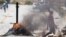 A man walks past burning barricades during a farm workers strike in De Doorns, South Africa, November 14, 2012.