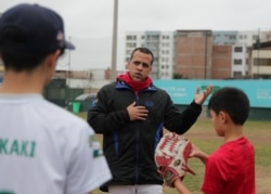 Baseball player Juan Casas, a Venezuelan migrant and naturalized Peruvian, instructs his team during a practice session in Lima, Peru, July 18, 2019.