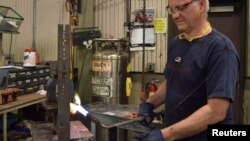 Mark Hoedee, a worker at transformer manufacturer RoMan Manufacturing welds a secondary coil for a transformer at the company's factory in Grand Rapids, Michigan, Dec. 7, 2016. 