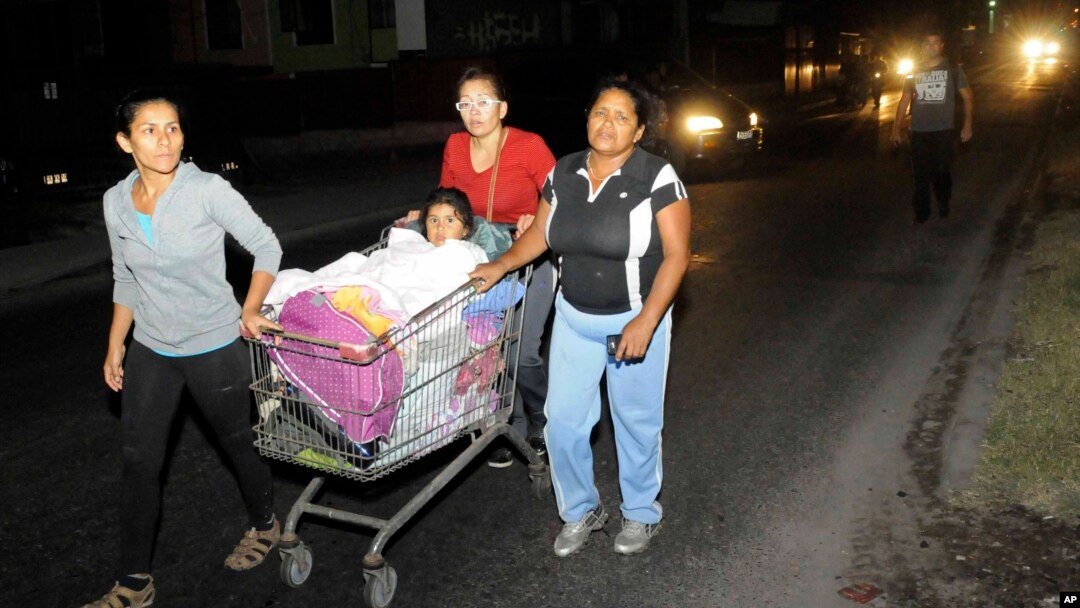 Tiga perempuan mendorong seorang anak yang dalam kereta belanja saat melakukan evakuasi menyusul gempa kuat di Iquique, Chile, Kamis dini hari (3/4). (AP/Cristian Vivero) 