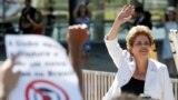 A Presidente suspensa, Dilma Rousseff, acena aos seus apoiantes à saída do Palácio do Planalto em Brasília.