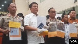 Polisi menunjukkan barang bukti kasus perdagangan orang yang melibatkan tujuh tersangka dan empat korban di Bareskrim, Selasa (16/7). (VOA/Fathiyah)