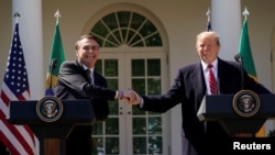 El presidente de EE.UU. Donald Trump y el visitante presidente de Brasil, Jair Bolsonaro, se dan la mano durante una conferencia de prensa conjunta en el Jardín de las Rosas de la Casa Blanca, el martes 19 de marzo de 2019.