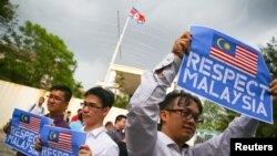 FILE - Members of the youth wing of the National Front, Malaysia's ruling coalition, hold placards during a protest at the North Korea embassy, following the murder of Kim Jong Nam, in Kuala Lumpur, Malaysia, Feb. 23, 2017.