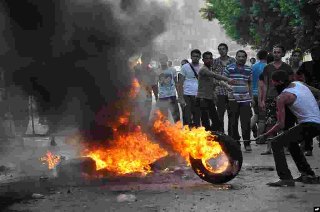 Egyptian protesters burn tires as they clash with riot police outside the U.S. embassy in Cairo, Egypt, September 13, 2012.