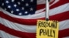 A sign hangs in front of an American flag, as a handful of supporters of President Donald Trump continue to protest outside the Pennsylvania Convention Center, in Philadelphia, November 10, 2020. 