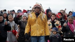 Chief Arvol Looking Horse, spiritual leader of the Sioux Nation, leads his people to peacefully pray near a law enforcement barricade just outside a Dakota Access pipeline construction site north of Cannon Ball, North Dakota, Oct. 29, 2016. 