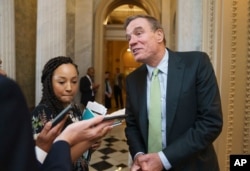 FILE - Sen. Mark Warner, D-Va., the Senate Intelligence Committee chairman, speaks with reporters at the Capitol in Washington, June 10, 2021.