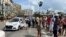 People gather near police cars during protests against and in support of the government, amidst the coronavirus disease (COVID-19) outbreak, outside the Capitol building, in Havana, Cuba, July 11, 2021. 