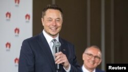 South Australian Premier Jay Weatherill, right, listens to Tesla Chief Executive Officer Elon Musk speak during an official ceremony in Adelaide, Australia, July 7, 2017. to announce that Tesla will install the world's largest grid-scale battery in the So