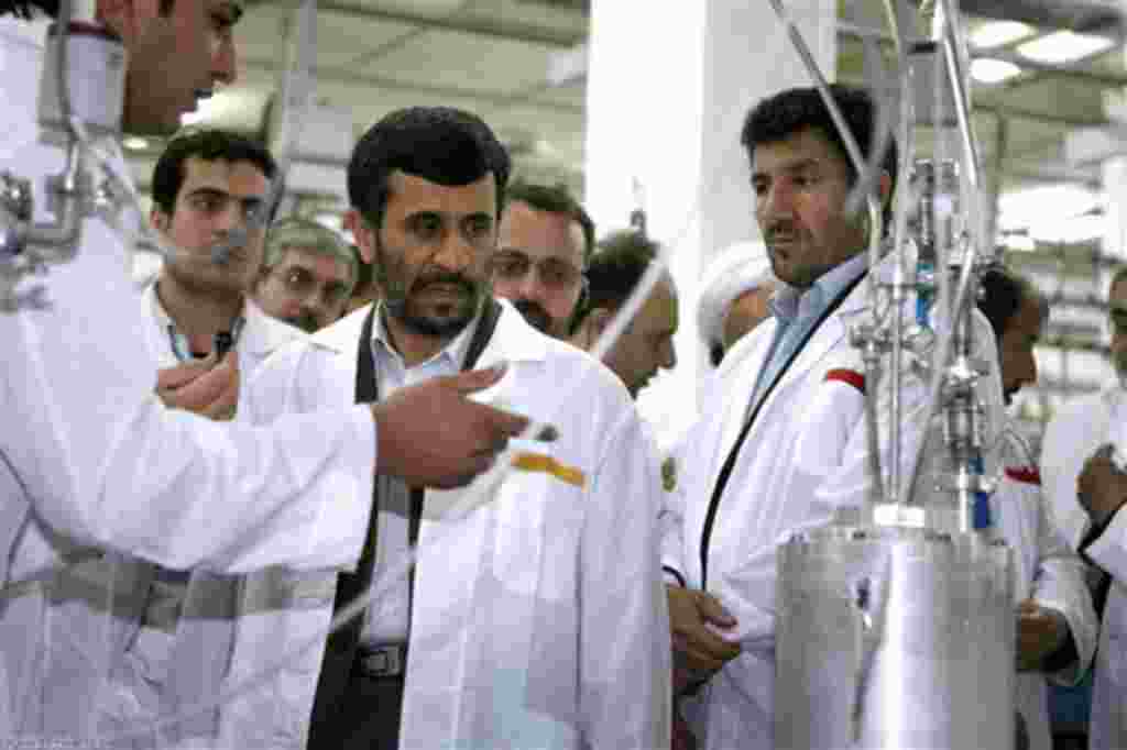 In this photo released by the Iranian President's Office, Iranian President Mahmoud Ahmadinejad, center, listens to a technician during his visit of the Natanz Uranium Enrichment Facility some 200 miles (322 kilometers) south of the capital Tehran, Iran,