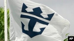FILE - The Royal Caribbean Cruises Ltd., flag waves outside the headquarter building in Miami, Florida.