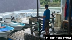 A worker guts fish caught by Palauan fishermen at a fish market by Ngermalk Bay in Palau, Oct. 16, 2024.