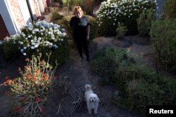 El 14 de abril de 2023, una mujer se para en el barrio acomodado de Santiago con plantas nativas bien adaptadas que pueden crecer en climas áridos.  (REUTERS/Iván Alvarado)