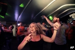 Rallygoers dance at a rock show Aug. 5, 2021, in Sturgis, SD. The Sturgis Motorcycle Rally started Friday, even as coronavirus cases are rising in South Dakota.