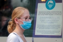 FILE - A woman wears a mask against COVID-19, following the CDC's recommendation that even fully vaccinated Americans wear masks to limit the spread of the highly transmissible coronavirus delta variant, in New York City, July 27, 2021.