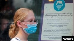 FILE - A woman wears a mask against COVID-19, following the CDC recommendation that fully vaccinated Americans wear masks as the highly transmissible delta variant has led to a surge in infections, in New York City, New York, July 27, 2021.