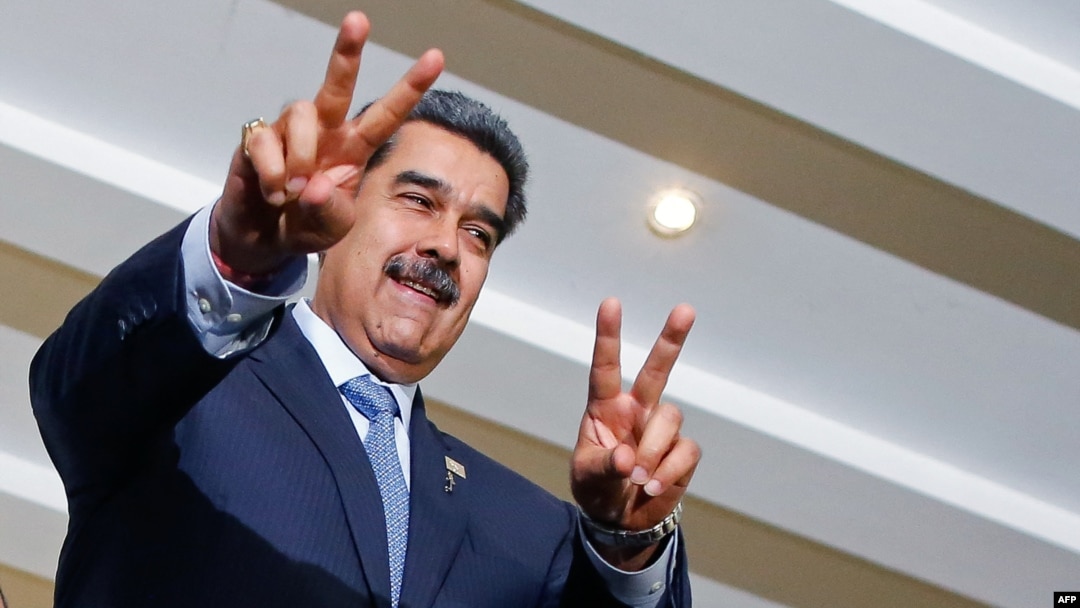 El presidente Nicolás Maduro saluda con los signos de victoria en una cumbre de líderes suramericanos en Brasilia, el 30 de mayo de 2023.