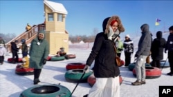 Nasrieen Habib, left, and Makiya Amin pull their snow tubes on top of a hill during an outing organized by the group Habib founded to promote outdoors activities among Muslim women, at Elm Creek Park Reserve in Maple Grove, Minn., Jan. 4, 2025.