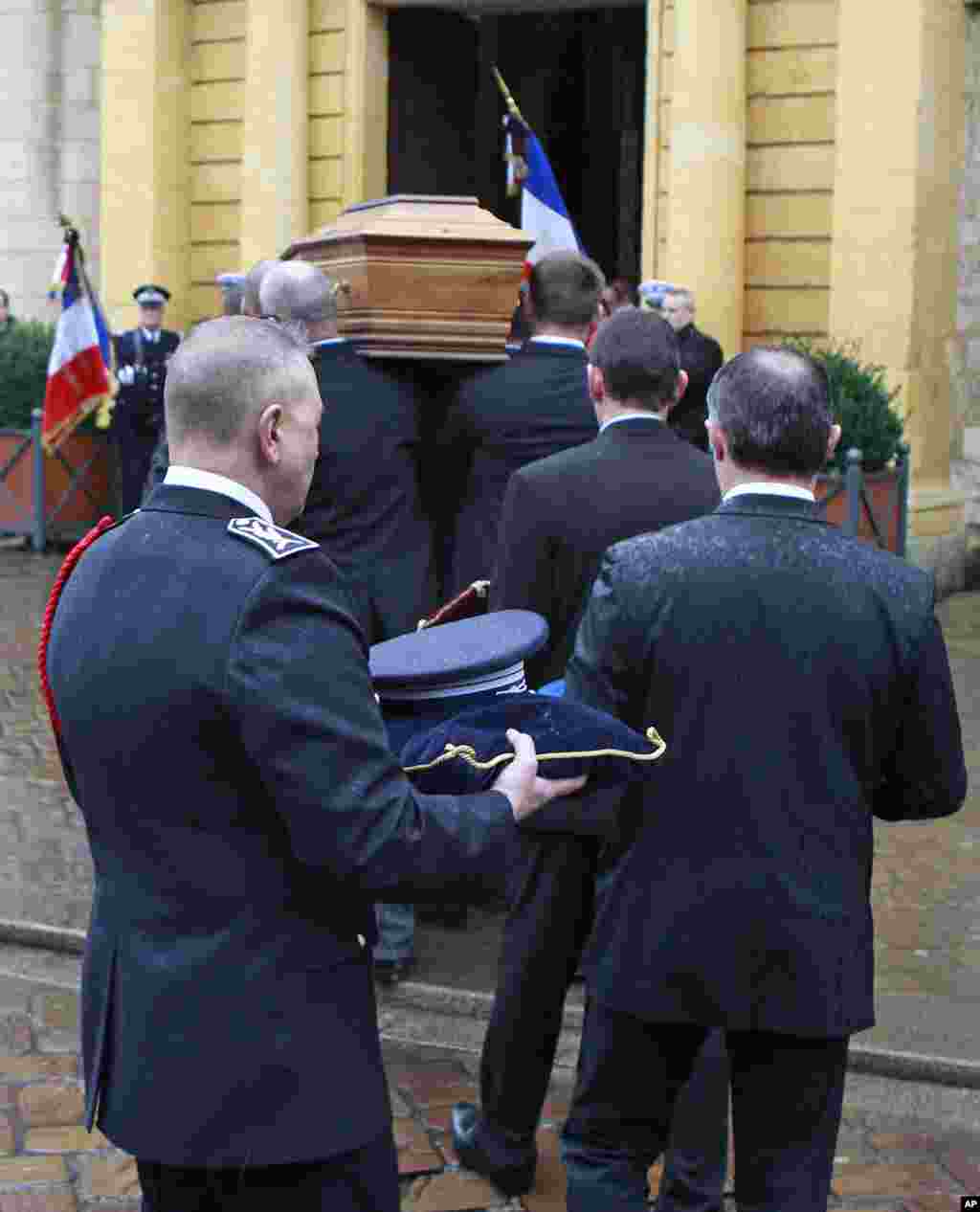 The coffin of police officer Franck Brinsolaro is carried into Sainte Croix church for the funeral ceremony in Bernay, western France, Jan. 15, 2015.