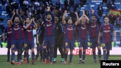 Pemain Barcelona, Gerard Pique, dan rekan-rekan satu tim memberikan tepuk tangan ke arah para penggemarnya di akhir pertandingan klub tersebut melawan Real Madrid di Madrid, 23 Desember 2017.