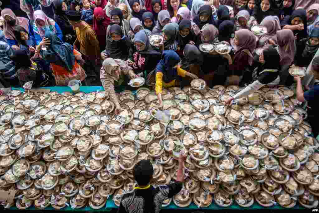 Muslims receive free iftar meals to break their fast during the Islamic holy fasting month of Ramadan at the Jogokariyan Mosque in Yogyakarta, Indonesia.