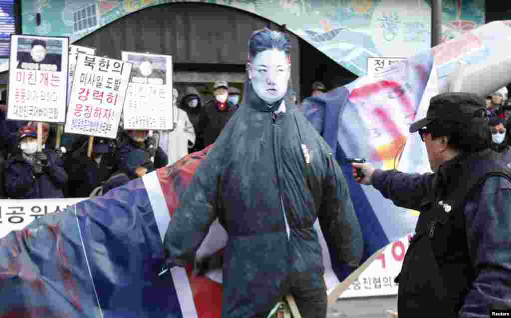 An anti-North Korean protester aims a mock pistol at an effigy of North Korean leader Kim Jong-Un during a protest blaming the North's rocket launch in central Seoul December 12, 2012. North Korea successfully launched a rocket on Wednesday, boosting the 