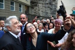 FILE - Placido Domingo poses for selfies at the Festspielhaus opera house after he performed Luisa Miller by Giuseppe Verdi in Salzburg, Austria, Aug. 25, 2019.