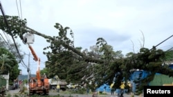 Trabajadores reparan una línea eléctrica dañada por un árbol que cayó de los fuertes vientos causados por la tormenta tropical Eta en San Salvador, El Salvador, el 4 de noviembre de 2020.