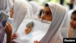 Students hold pictures of schoolgirl Malala Yousafzai, who was shot by the Taliban, during a tribute at the Pakistani Embassy in Abu Dhabi, October 15, 2012. 