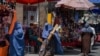 身穿罩袍的妇女在喀布尔一处市场购物。(2021年8月23日)