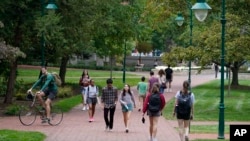 FILE - Students walk to and from classes on the Indiana University campus, Thursday, Oct. 14, 2021, in Bloomington, Ind. (AP Photo/Darron Cummings, File)