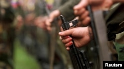 FILE - A fighter of the Revolutionary Armed Forces of Colombia (FARC) participates in a parade in the Villa Colombia camp near San Vicente del Caguan,Caqueta province, Colombia, April 29, 2000.