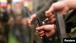 FILE - A fighter of the Revolutionary Armed Forces of Colombia (FARC) participates in a parade in the Villa Colombia camp near San Vicente del Caguan,Caqueta province, Colombia, April 29, 2000.