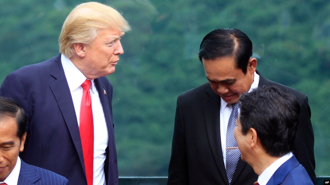 Presiden Donald Trump (kiri), berbicara dengan Perdana Menteri Thailand Prayuth Chan-ocha pada sesi foto pertemuan puncak Asia-Pacific Economic Cooperation (APEC) di Danang, Vietnam, 11 November 2017. 