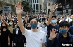 Demonstrators raise their hands as they attend a protest at the Central District in Hong Kong, Nov. 15, 2019.